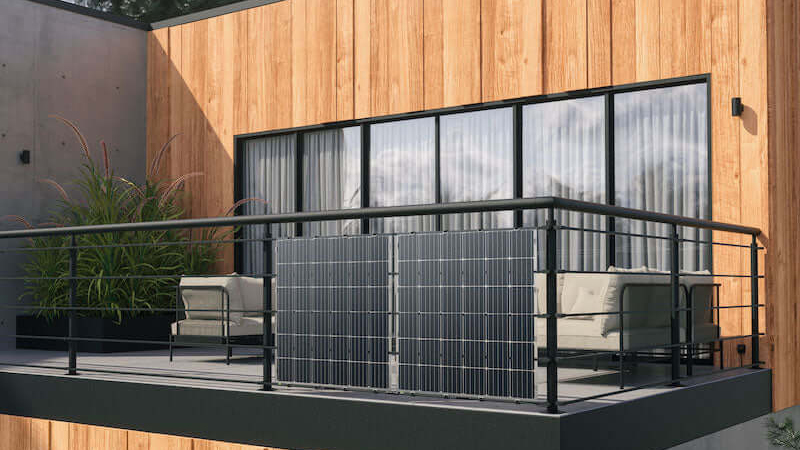 Zwei Solarpaneele sind auf dem Außengeländer eines Balkons montiert
