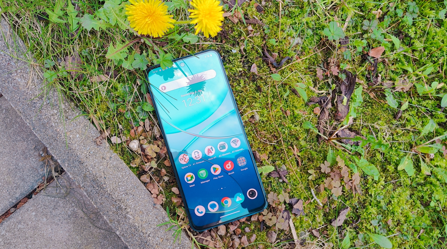 Vivo V40 SE Smartphone auf einer gründen Blumenwiese liegend