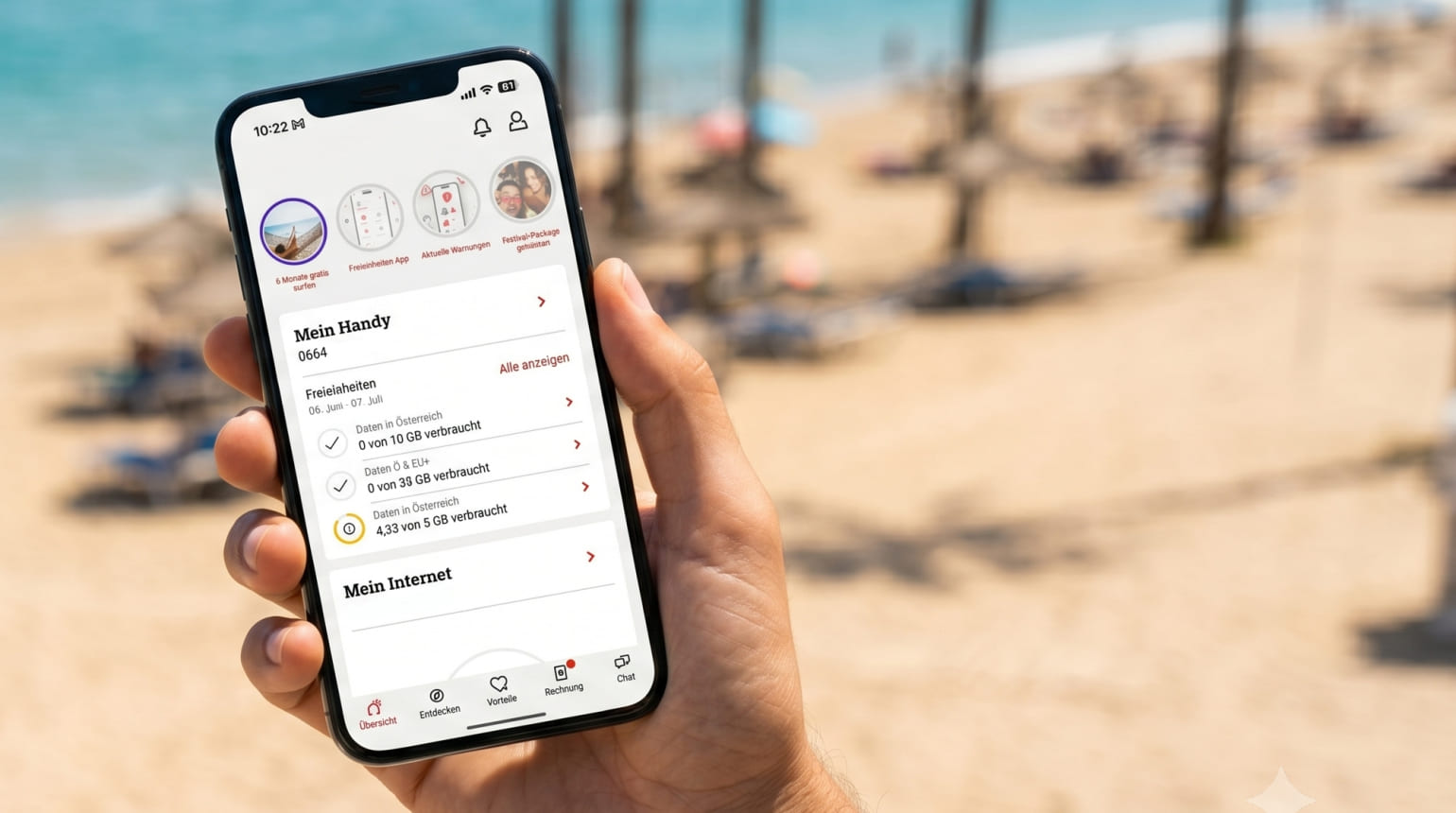 Hand hält Smartphone mit geöffneter Mobilfunk-App, im Hintergrund Strand.