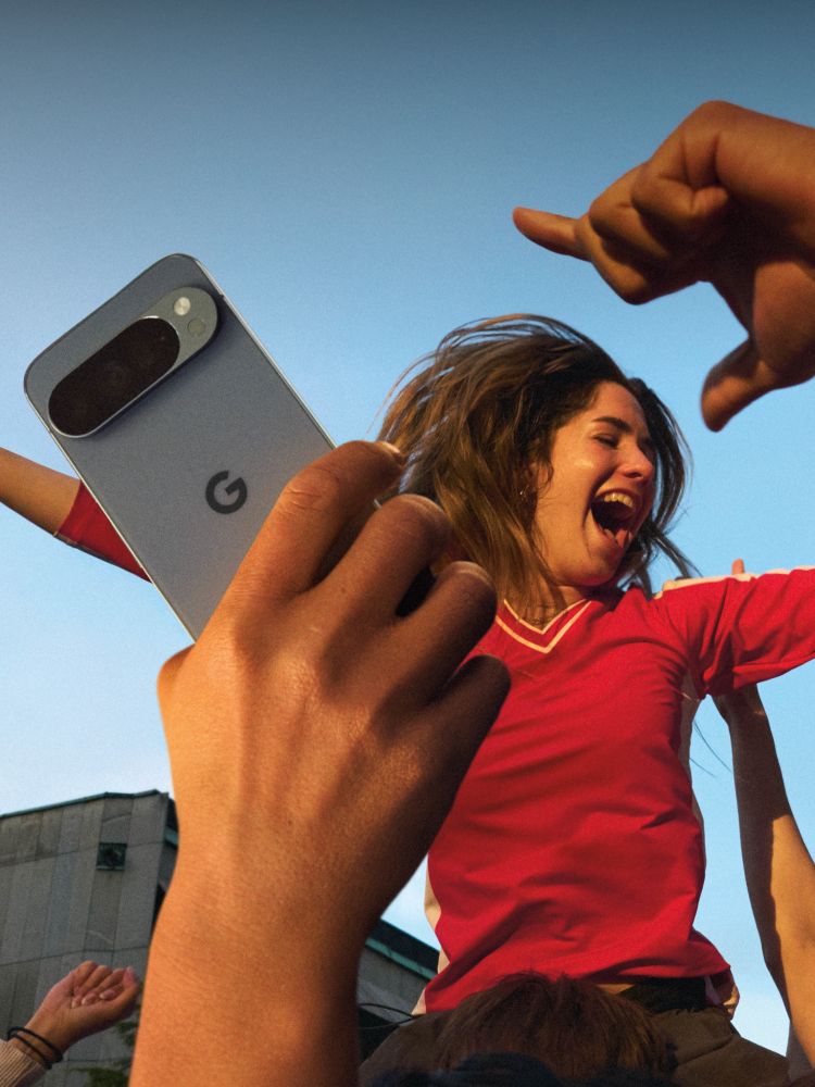 Jubelnde Menschenmenge hebt ein Kind hoch, viele halten Smartphones zum Fotografieren in die Luft.