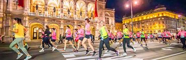Bild zeigt Läufer beim Vienna Nightrun wie sie entlang der Oper in Wien laufen.